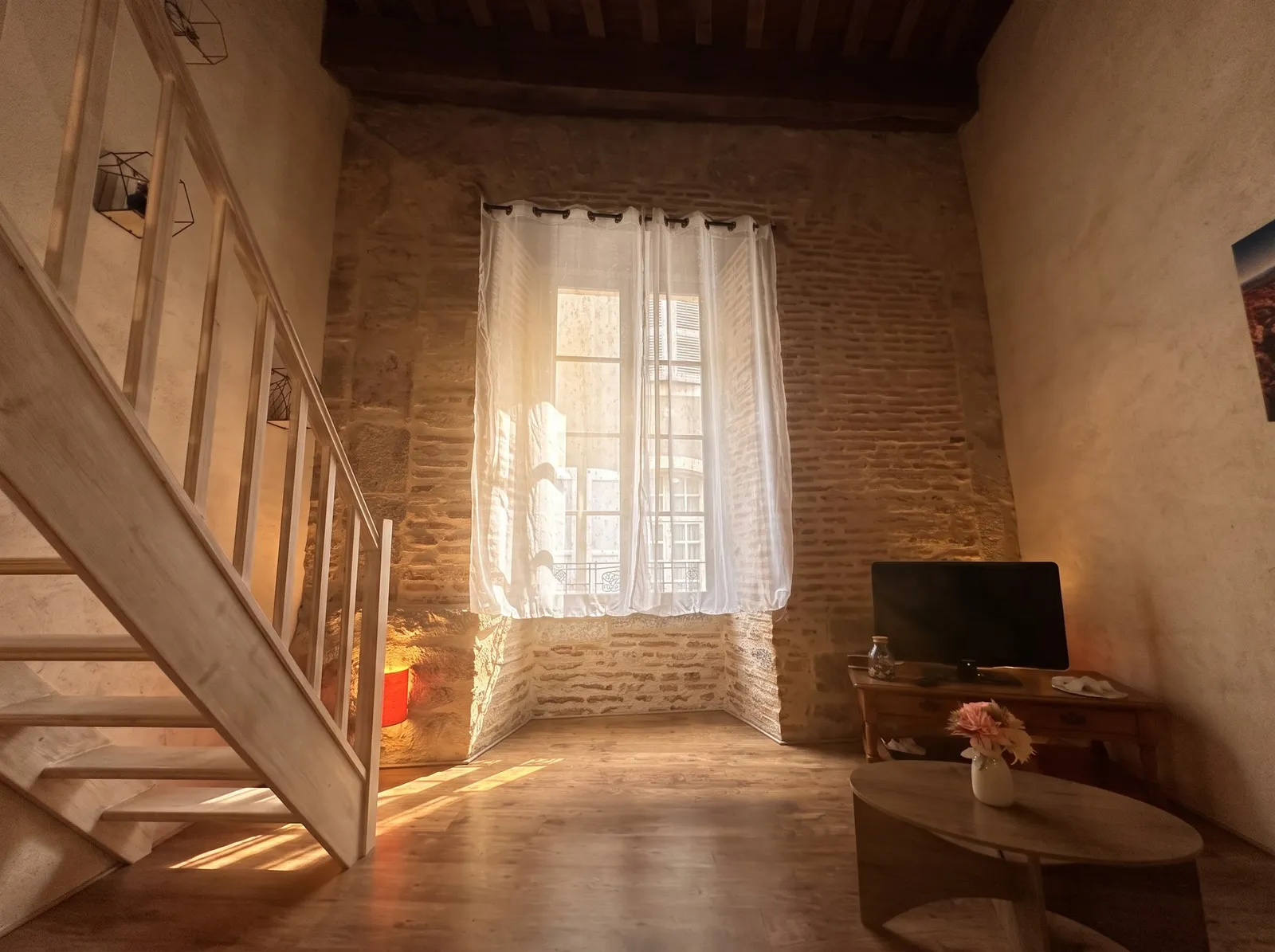 Séjour sous les poutres et escalier vers la mezzanine